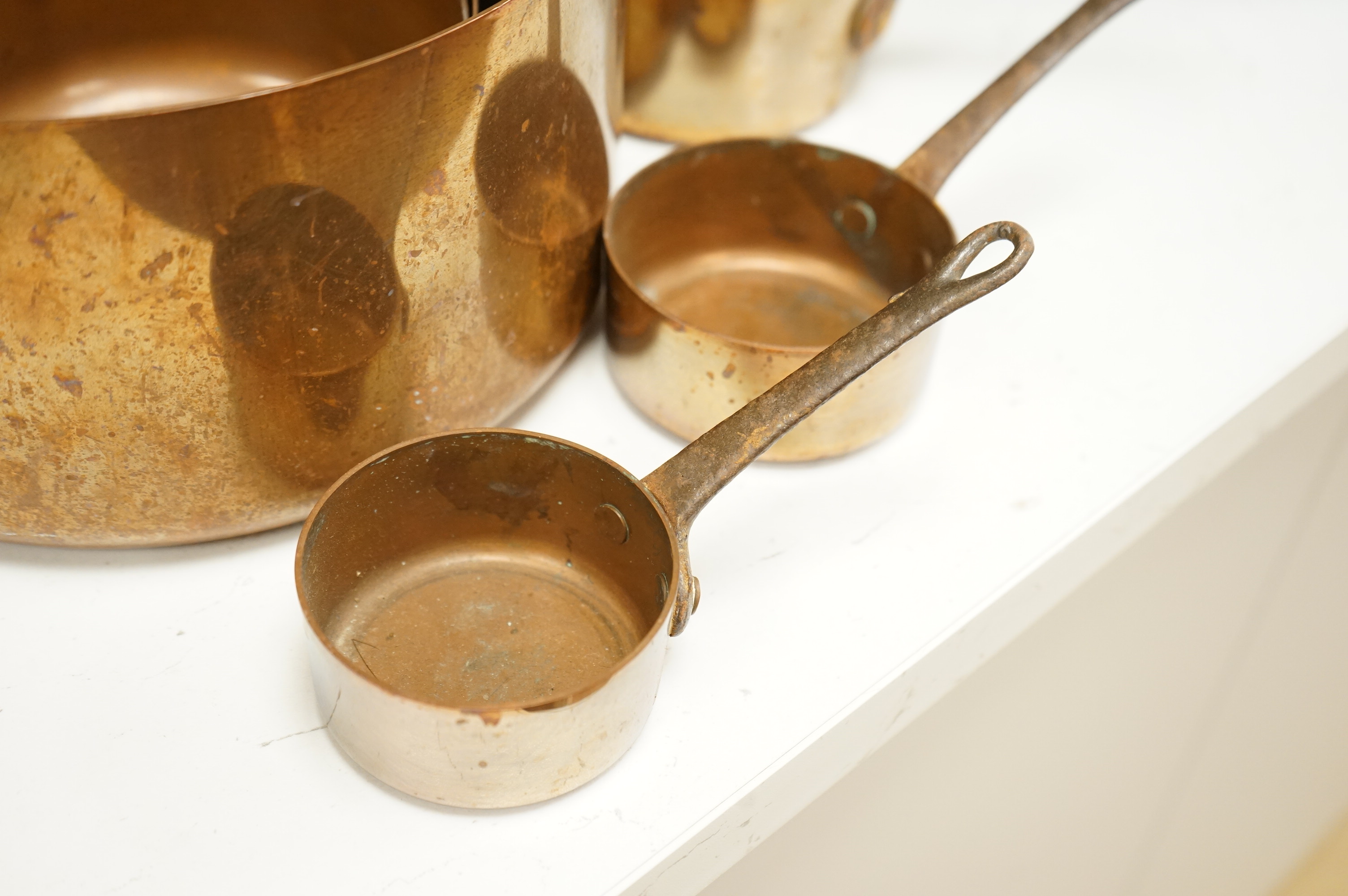 A graduated set of copper saucepans, largest 20.5cm diameter, smallest 6.5cm